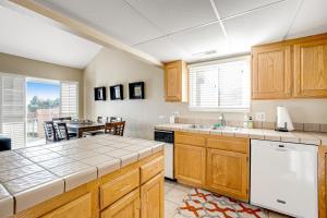 a kitchen with wooden cabinets and a dining table at Penthouse at the Village in St. George