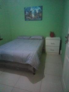 1 dormitorio verde con 1 cama y vestidor en Jackies Guest House, en Durban