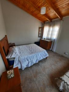 a bedroom with a bed and a wooden ceiling at MarraHOME in El Challao