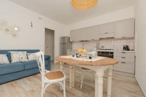 a kitchen with a table and a blue couch at Casa Ono - Appartamento con 2 Camere e 2 bagni in centro abitato in Orosei +26 photos