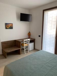 a bedroom with a desk and a bed and a chair at Casa Fiorita in Negrar
