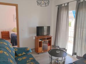 sala de estar con sofá y TV en confortable y luminoso piso 5 camas, parking gratis en Málaga