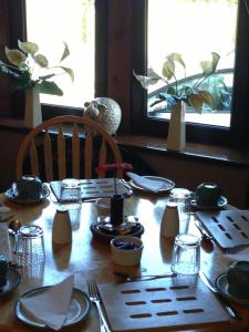 ストランラーにあるNeptunes Rest Guest Hotelの木製テーブル(皿、調理器具付)