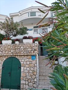 a white house with a green door and stairs at Apartment Lucia in Pag