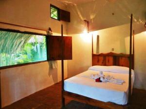 a bedroom with a bed and a large window at La Buena Vista in Puerto Ángel