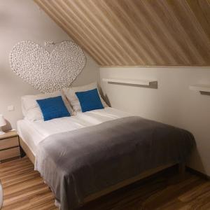 een slaapkamer met een bed met een hart aan de muur bij Pokoje Gościnne Kacper Blisko Gondoli in Szczyrk