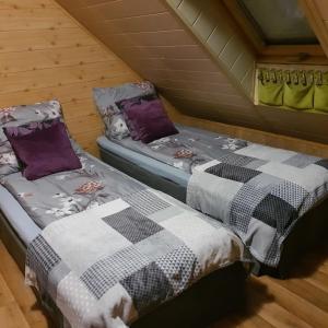 two beds in a log cabin with at Pokoje Gościnne Kacper Blisko Gondoli in Szczyrk
