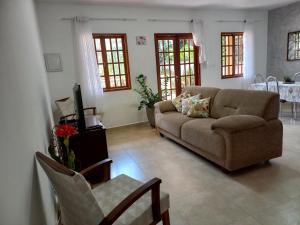 a living room with a couch and a tv at Casa Laranja Lençóis - BA in Lençóis