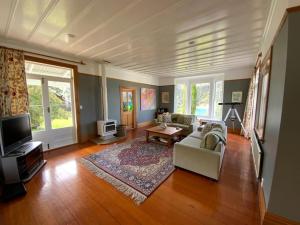 a living room with a couch and a tv at Glenfern Sanctuary in Port Fitzroy