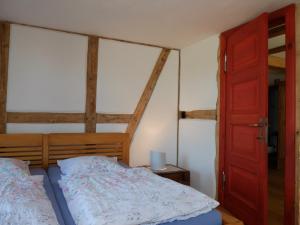 ein Schlafzimmer mit einem Bett und einer roten Tür in der Unterkunft Botanische Botschaft in Strodehne + 43 Fotos