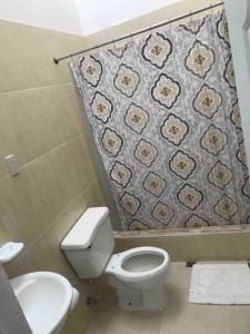 y baño con aseo y cortina de ducha. en Cozy 2 Bedrooms Apartment In Puerto Plata en San Felipe de Puerto Plata