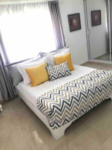 1 dormitorio con cama con almohadas y ventana en Cozy 2 Bedrooms Apartment In Puerto Plata en San Felipe de Puerto Plata