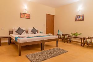 een slaapkamer met een bed en 2 stoelen in een kamer bij Western Edge Kasauli !Lawn! Bonfire! Peace! Pvt Villa ! in Kasauli