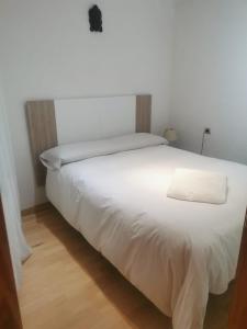 a white bed with a white pillow on top of it at Casa Noell in León