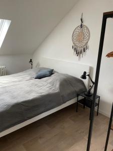 a white bedroom with a bed and a chandelier at Ferienwohnung Mica in Bad Kissingen