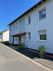 Una casa blanca con el número. en Ferienwohnung Mica en Bad Kissingen