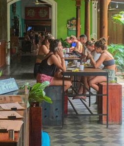 un grupo de personas sentadas en una mesa en un restaurante en Oasis Hostel en Granada