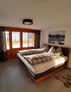 ダボスにあるResidenz Davos von Swisspartmentsのベッドルーム1室(ベッド2台、大きな窓付)