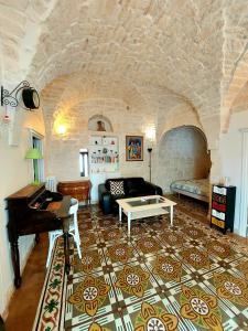 uma sala de estar com um piano e um sofá em Apartment Mammacara em Ceglie Messapica