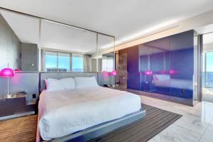 ラスベガスにあるPrivate Luxury Panoramic Suite at Palms Placeの紫の壁と窓が特徴のベッドルーム1室