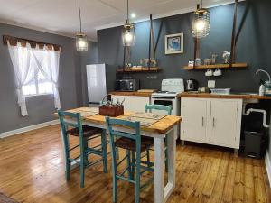 a kitchen with a table and chairs in a room at Môreson Cottage in Klaarstroom