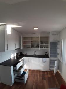 a kitchen with white cabinets and a black counter top at Apartment Seeblick in Arbon von Swisspartments in Arbon