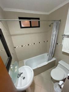 uma casa de banho com um lavatório, uma banheira e um WC. em Hotel Plaza Monte Carlo em Guayaquil