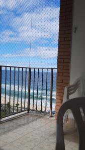 a view of the ocean from a balcony with a bench at Flat 2 suites com vista para o mar e lagoa. in Rio de Janeiro