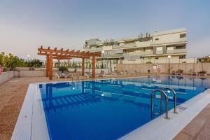 a large swimming pool in front of a building at El Medano, La Tejita in El Médano