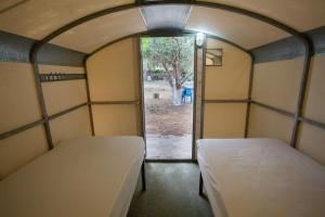 two beds in a room with an open door at Camping Koula in Parikia