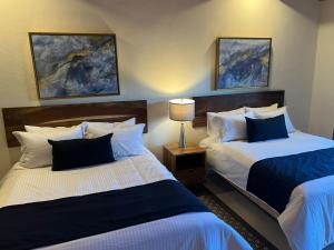 a hotel room with two beds and a lamp at Bosque Escondido in Mazamitla