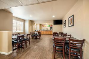 a dining room with wooden tables and chairs at Quality Inn & Suites near NAS Fallon in Fallon