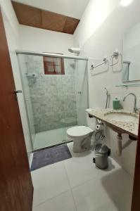 a bathroom with a shower and a toilet and a sink at Apartamento lençóis 103 in Lençóis