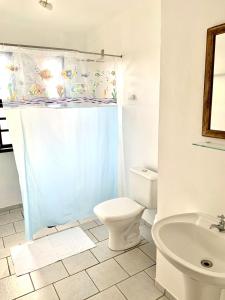 a white bathroom with a toilet and a sink at Pousada Do Farol in Capão da Canoa