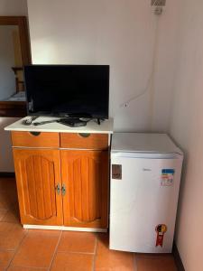 a small desk with a television and a small refrigerator at Pousada Do Farol in Capão da Canoa