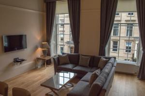 a living room with a couch and a large window at Dreamhouse at Blythswood Apartments Glasgow in Glasgow