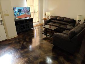 a living room with a couch and a flat screen tv at Chateau 18 in Hammond