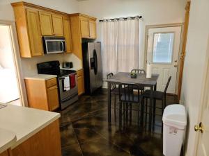 a kitchen with a table with chairs and a refrigerator at Chateau 18 in Hammond