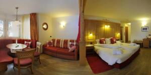 Habitación de hotel con cama y sala de estar. en Hotel Alba Wellness & Spa, en Canazei