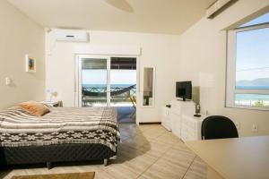 a bedroom with a bed and a view of the ocean at Campeche Beach House in Florianópolis