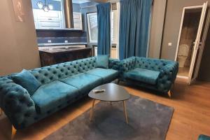 Una sala de estar con un sofá azul y una mesa. en BalcescuSuite, en Bucarest