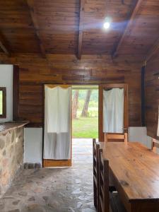 a dining room with a wooden table and a large window at Casa IMA in San Lorenzo