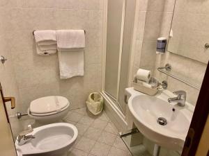 a white bathroom with a toilet and a sink at Roma Castle Termini in Rome