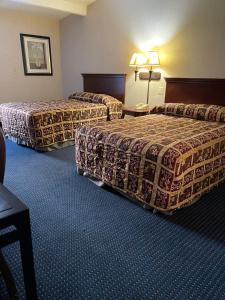 um quarto de hotel com duas camas e uma mesa em Budget Inn Temple Hills em Temple Hills