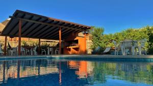 a swimming pool with chairs and a pavilion at Posada Cova Del Sol in La Pedrera