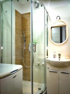 La salle de bains est pourvue d'une douche et d'un lavabo. dans l'établissement Mieszkanie z sercem - dwa pokoje, 300 m od morza, à Ustka