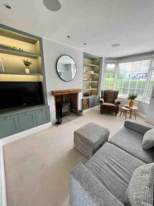 a living room with a couch and a tv at Modern Cottage Style House with Log Burner in Harrogate