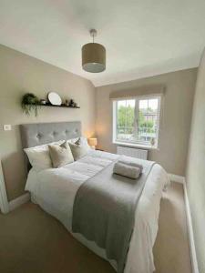 a bedroom with a large bed and a window at Modern Cottage Style House with Log Burner in Harrogate
