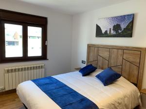 a bedroom with a large bed with blue pillows at Cal Canal in Montferrer