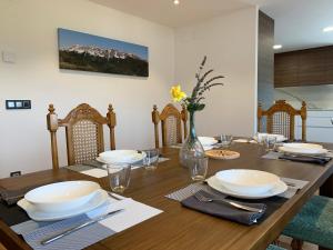 una mesa de comedor con platos y cuencos y un jarrón de flores en Cal Canal, en Montferrer